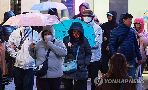 6일 저녁 거센 비바람이 부는 서울 홍대입구역 인근에서 시민들이 강풍을 맞으며 걸어가고 있다. [연합뉴스]